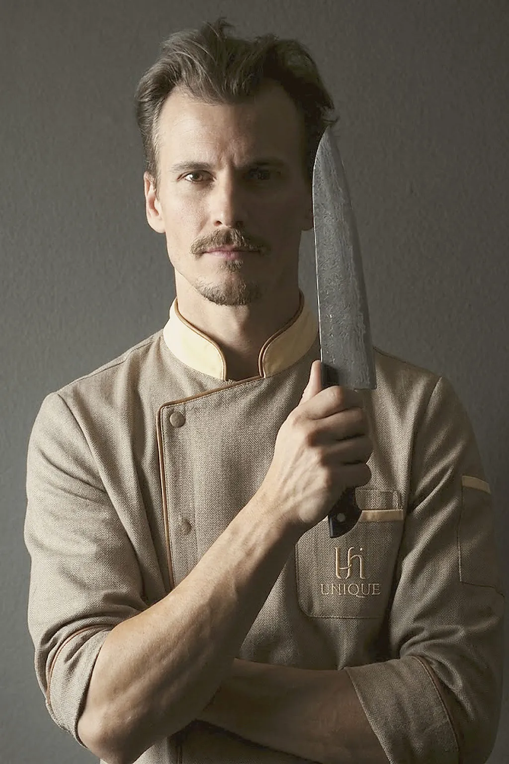 Unique House chef in the brand uniform holding a chef knife